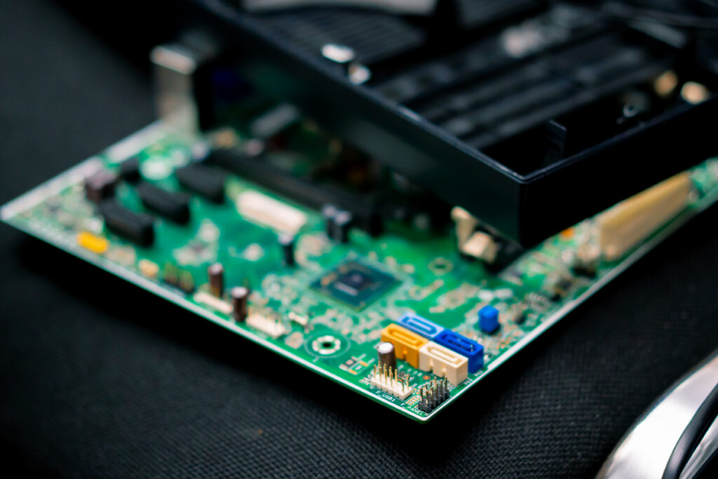 electronic prototype circuit board resting inside a custom-fabricated casing on an engineer's workbench